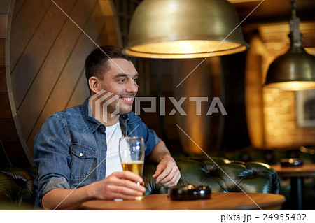 happy man drinking draft beer at bar or pub 24955402