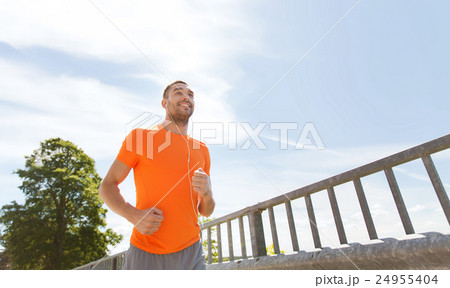 happy man with earphones running outdoors happy man with earphones running outdoors 24955404