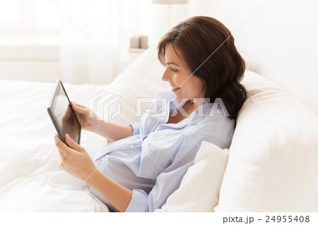 happy pregnant woman with tablet pc at home happy pregnant woman with tablet pc at home 24955408