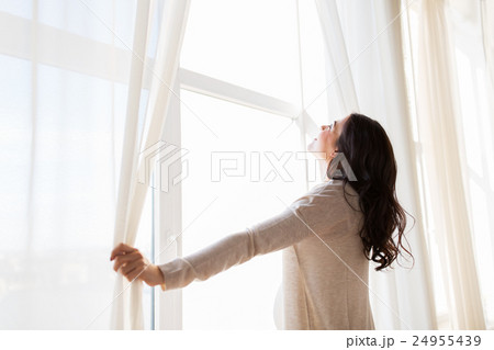 close up of pregnant woman opening window curtains close up of pregnant woman opening window curtains 24955439