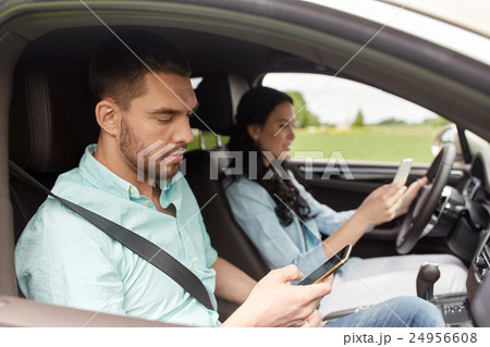 man and woman with smartphones driving in car man and woman with smartphones driving in car 24956608