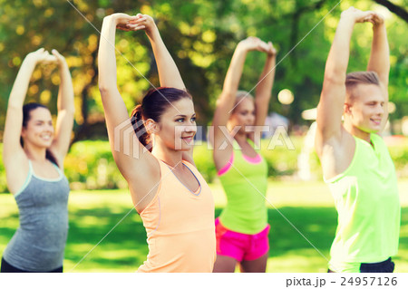 group of friends or sportsmen exercising outdoors 24957126