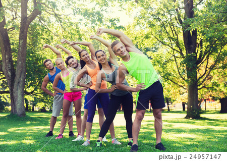 group of friends or sportsmen exercising outdoors group of friends or sportsmen exercising outdoors 24957147