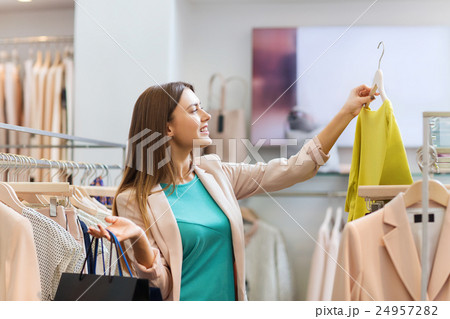 happy young woman choosing clothes in mall happy young woman choosing clothes in mall 24957282