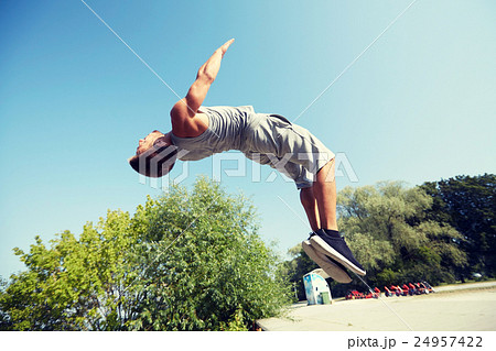 sporty young man jumping in summer park sporty young man jumping in summer park 24957422
