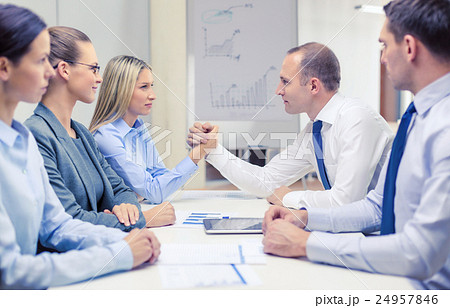 businesswoman and businessman arm wrestling 24957846