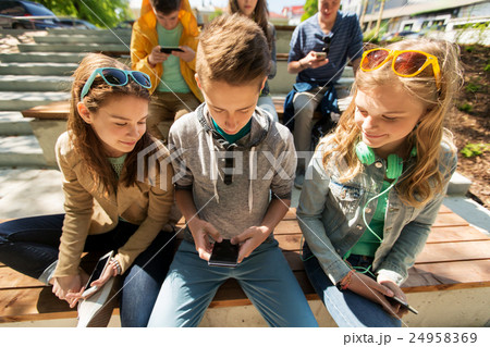 happy teenage friends with smartphones outdoors 24958369