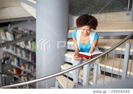 african student girl reading book at library 24958399