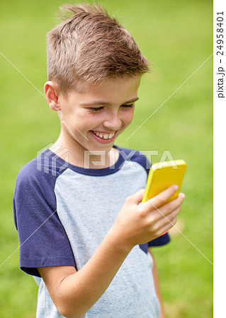 boy with smartphone playing game in summer park 24958401