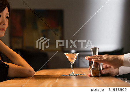 カクテルをつくるバーテンダーと女性 カクテルをつくるバーテンダーと女性 24958906
