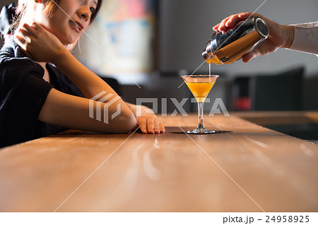 カクテルを注ぐバーテンと女性 24958925