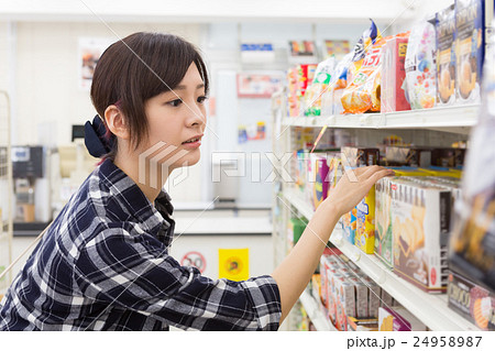 コンビニで買い物をする若い女性 コンビニで買い物をする若い女性 24958987