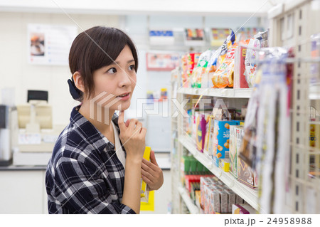 コンビニで買い物をする若い女性 24958988
