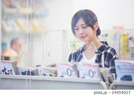 コンビニで立ち読みをする女性 24959027