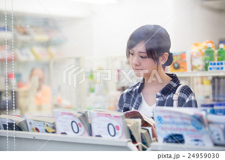 コンビニで立ち読みをする女性 コンビニで立ち読みをする女性 24959030
