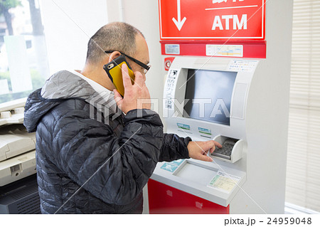 電話の指示でATMを操作する中年高年男性 24959048