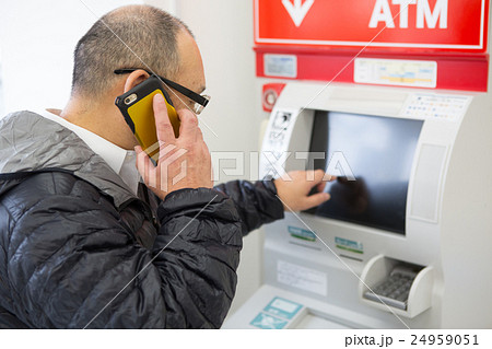 電話の指示でATMを操作する中年高年男性 24959051