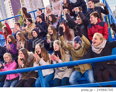 Sport fans clapping and singing on tribunes. 24966700