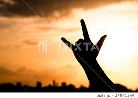 Hand silhouette under a sunset backdrop 24971244