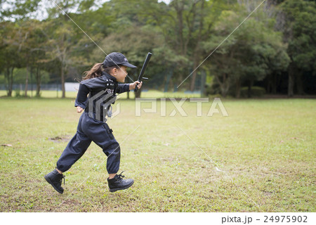 芝生で走る警察の衣装を着た女の子 24975902