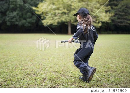 芝生で走る警察の衣装を着た女の子 24975909