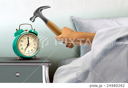 Hand hitting alarm clock with hammer 24980262