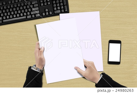 Hand holding blank paper top view 24980263