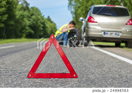 Male driver with spare wheel on the roadside Male driver with spare wheel on the roadside 24998563