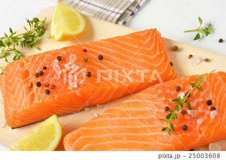raw salmon fillets on cutting board 25003608