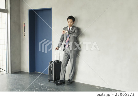 キャリーケースを持つビジネスマン 25005573