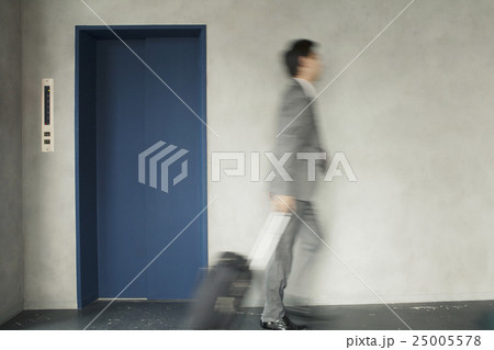 キャリーバックを持って移動するビジネスマン 25005578