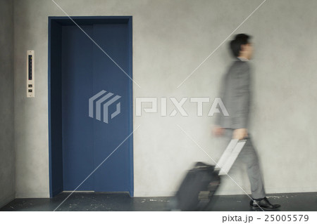 キャリーバックを持って移動するビジネスマン 25005579