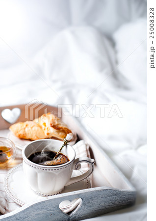 wooden tray with light breakfast on bed 25008328