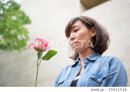 一輪のバラを持つ女性の写真素材