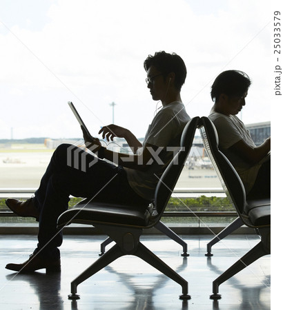 空港で出発を待つ男性 25033579