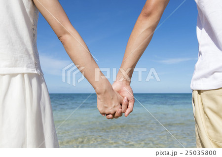 手を繋ぐカップルの手元の写真素材