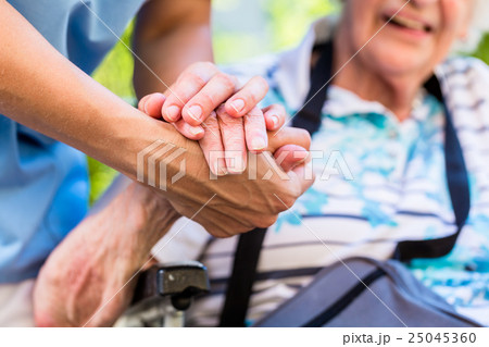 Nurse consoling senior woman holding her hand 25045360