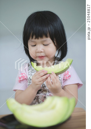 Lovely Asian child girl eating delicious melon 25048817