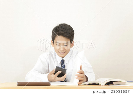 勉強よりスマートフォンに熱中する男の子 25051637