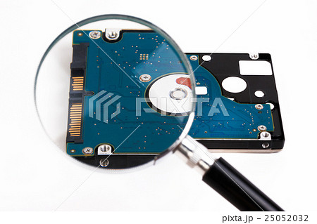 Magnifying glass over a computer hard drive. 25052032