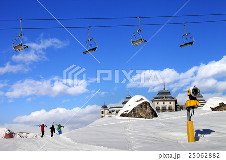 Chair-lift in blue sky and skiers on ski slope 25062882