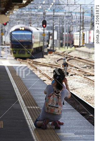 警笛を鳴らす電車 駅員をも無視して撮影する鉄ちゃん親子の写真素材