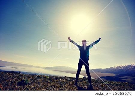 young woman open arms on sunrise mountain peak young woman open arms on sunrise mountain peak 25068676