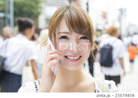 女性 スマホ 会話 カメラ目線 原宿 表参道 神宮前 ラフィレー原宿前 雑踏の写真素材