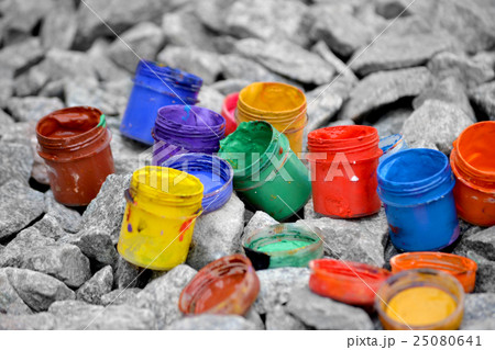 colored small paint cans lie on a gray pebble colored small paint cans lie on a gray pebble 25080641