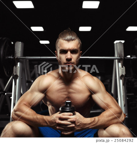 Young muscular man sitting with a bottle of water 25084292