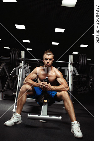 Young muscular man sitting with a bottle of water 25084337