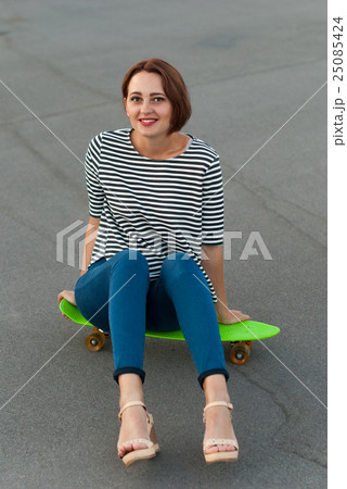 Attractive girl with a skateboard. 25085424