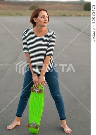 Girl with skateboard standing barefoot . Girl with skateboard standing barefoot . 25085425