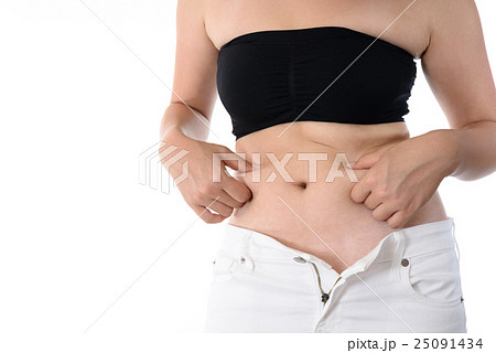 お腹の肉を指でつまむ女性 ダイエットイメージの写真素材